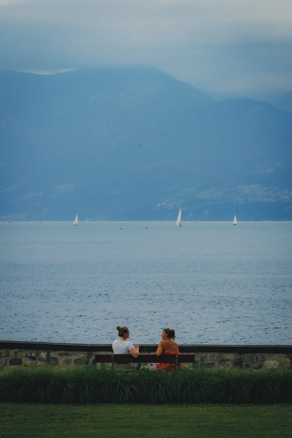 Two people on a bench by the lake
