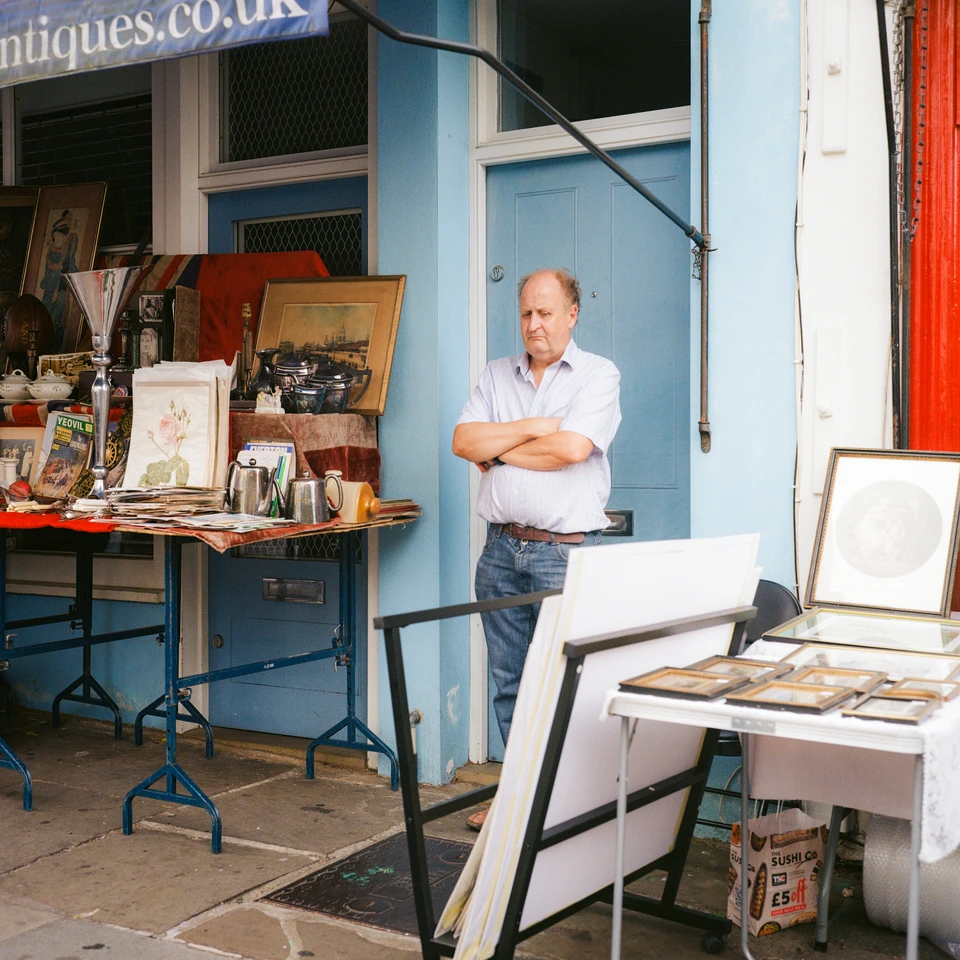 A stallholder, arms crossed