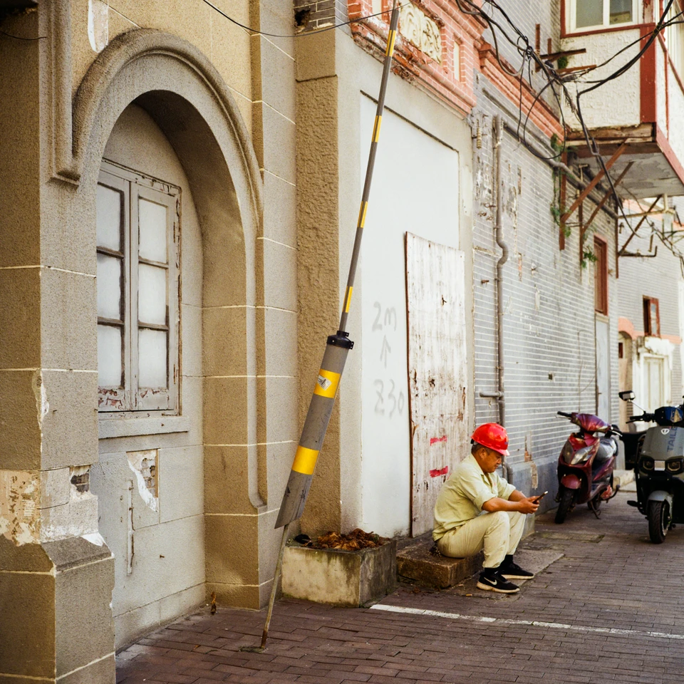 A worker resting at an arched doorway
